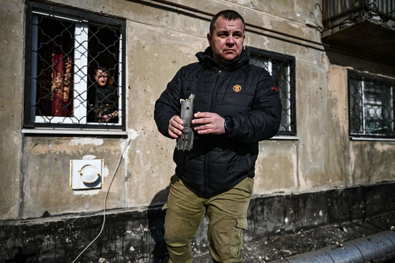 A man holds the remains of a mortar which exploded in front of a building in the town of Schastia, Ukraine, on February 22.