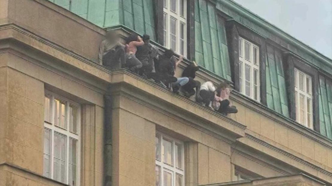 Students are seen hiding on a ledge at Charles University.