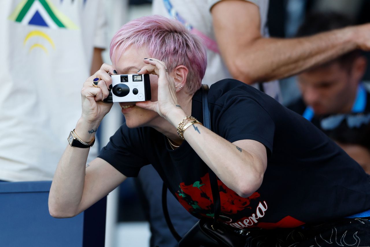 Former US soccer player Megan Rapinoe takes photos before the match. 