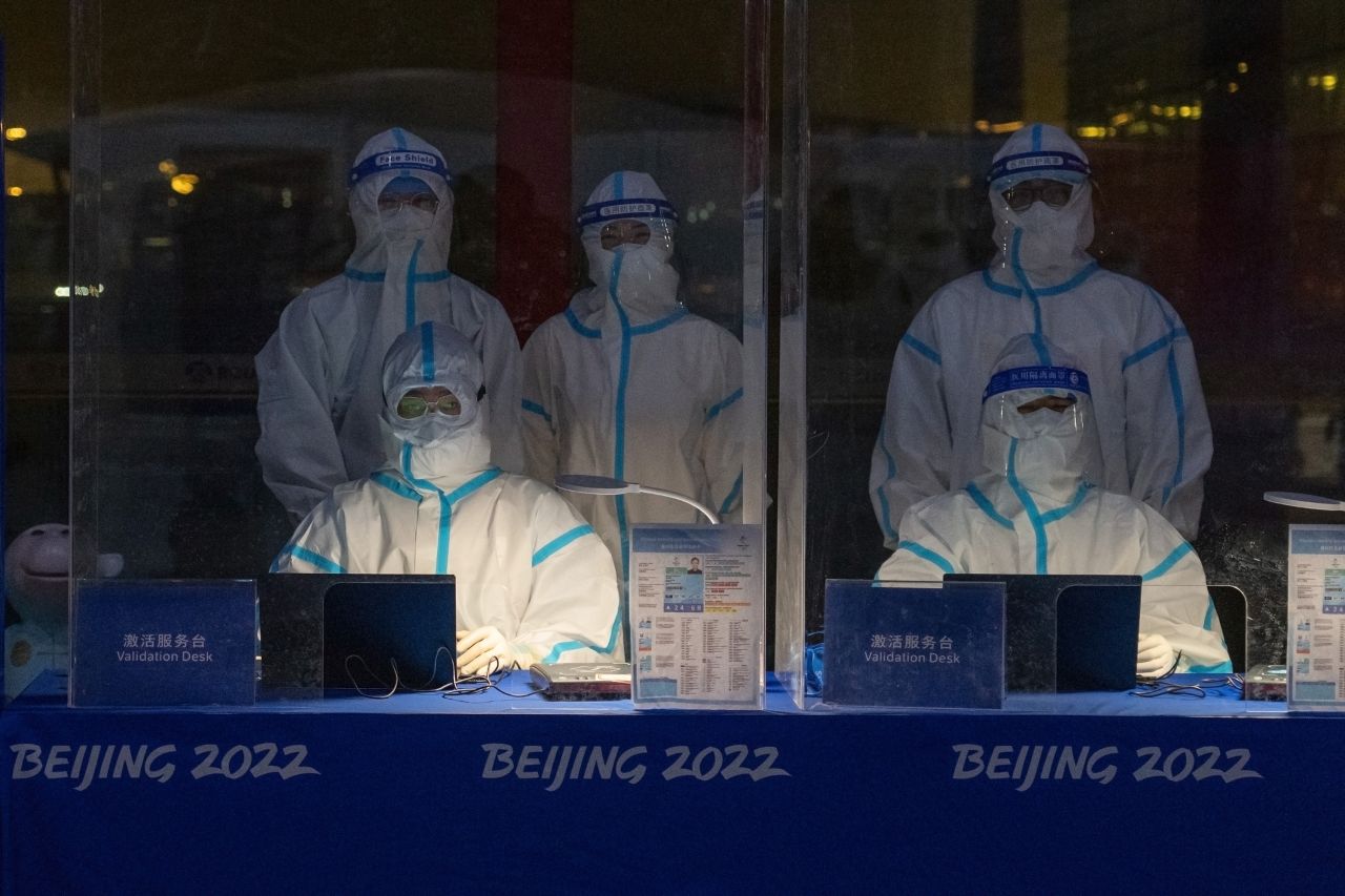 Officials decked in personal protective equipment wait to validate Olympic accreditation for people arriving at Beijing Capital International Airport on January 24 in Beijing, China.