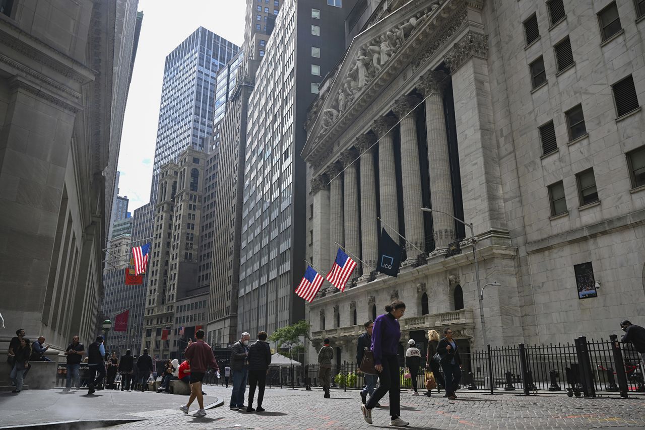 People walk past the New York Stock Exchange on Wall Street on September 27.