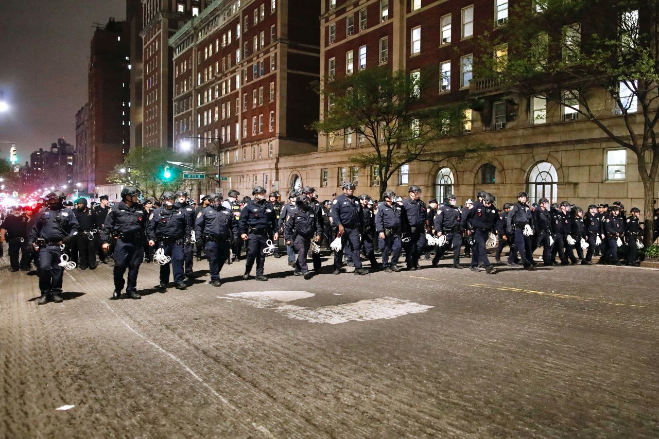 NYPD officers in riot gear march onto the Columbia University campus. 