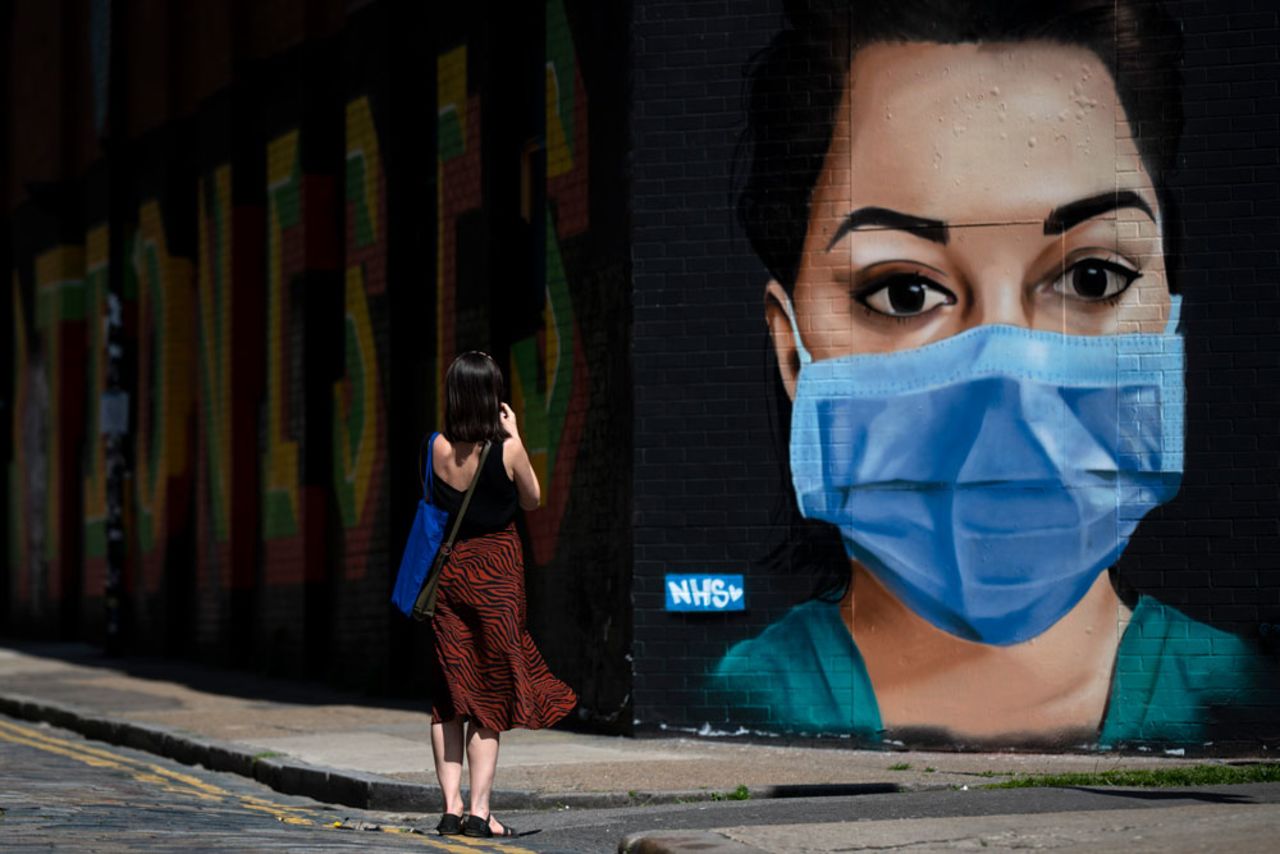 A woman takes a photo of graffiti on Brick Lane in East London on April 23, in London. 