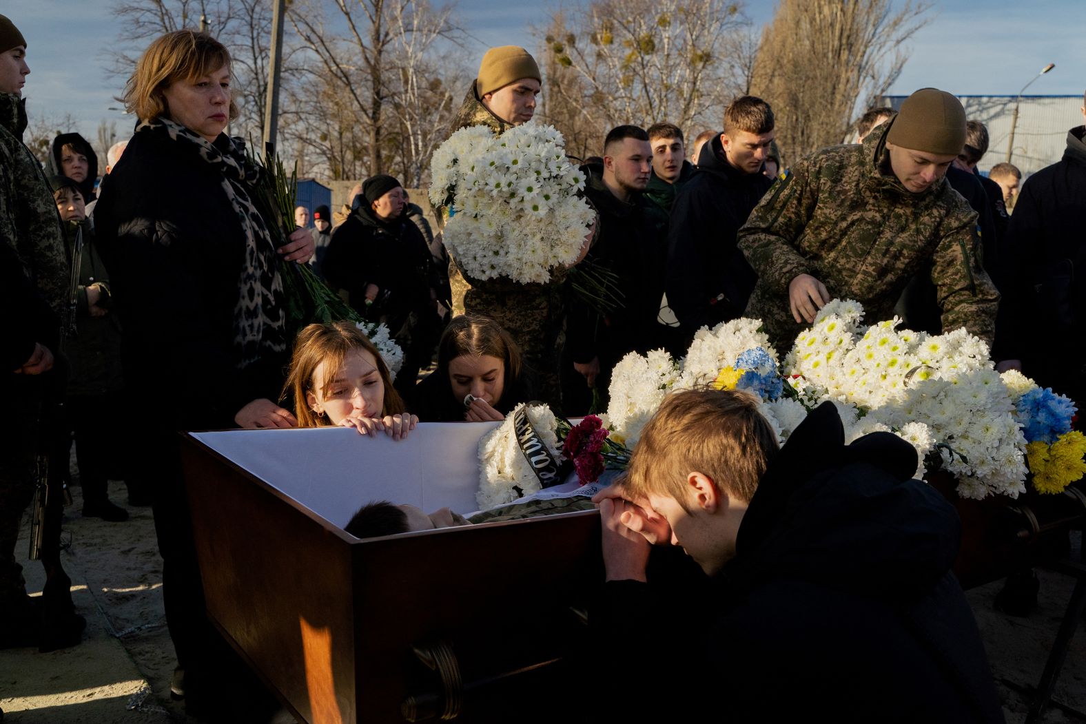 People mourn next to the coffin of Ukrainian serviceman Danylo Bobrykov during his funeral in Kyiv, Ukraine, on Thursday, January 2.