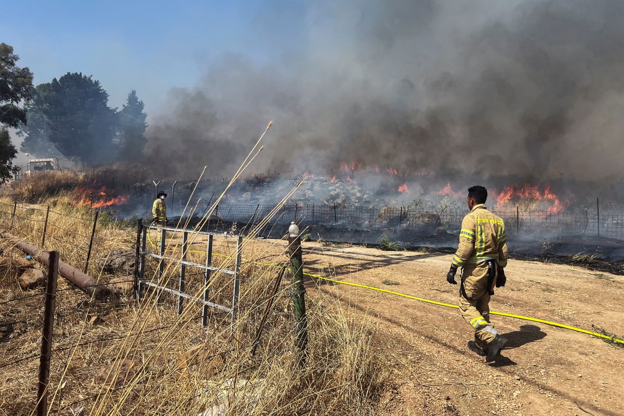 Israeli firefighters work following rocket attacks from Lebanon near the border on its Israeli side, on June 13.