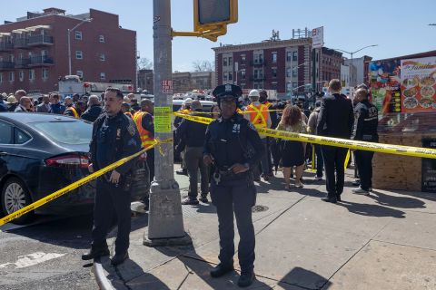 Members of the New York City Police Department stand near the crime scene after multiple people were shot at a subway station in Brooklyn, on April 12.