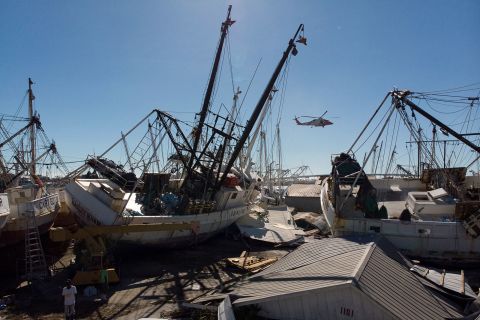 A US Coast Guard helicopter is seen amid stranded shrimp boats in a marina in Fort Myers Beach, Florida on Friday.