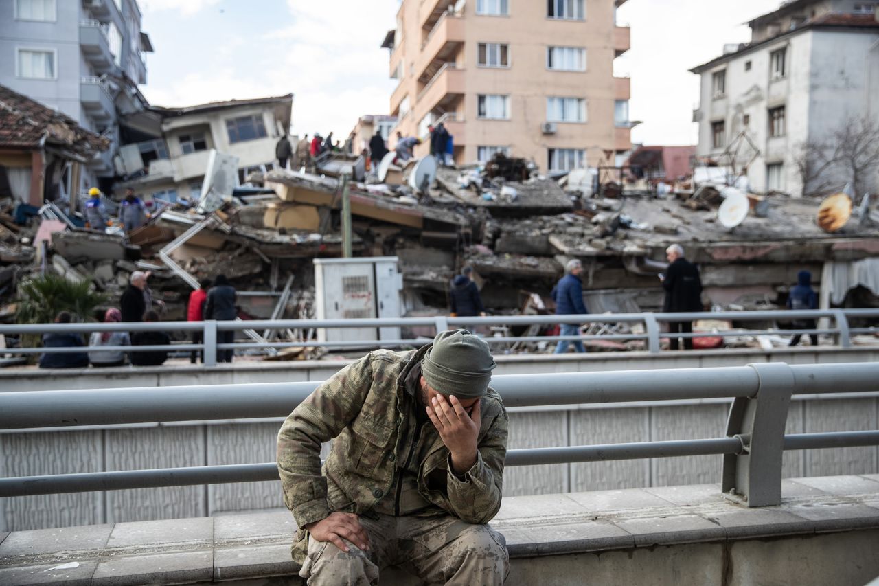 A soldier sits devastated near the collapsed building in Hatay, Turkey, on February 07.