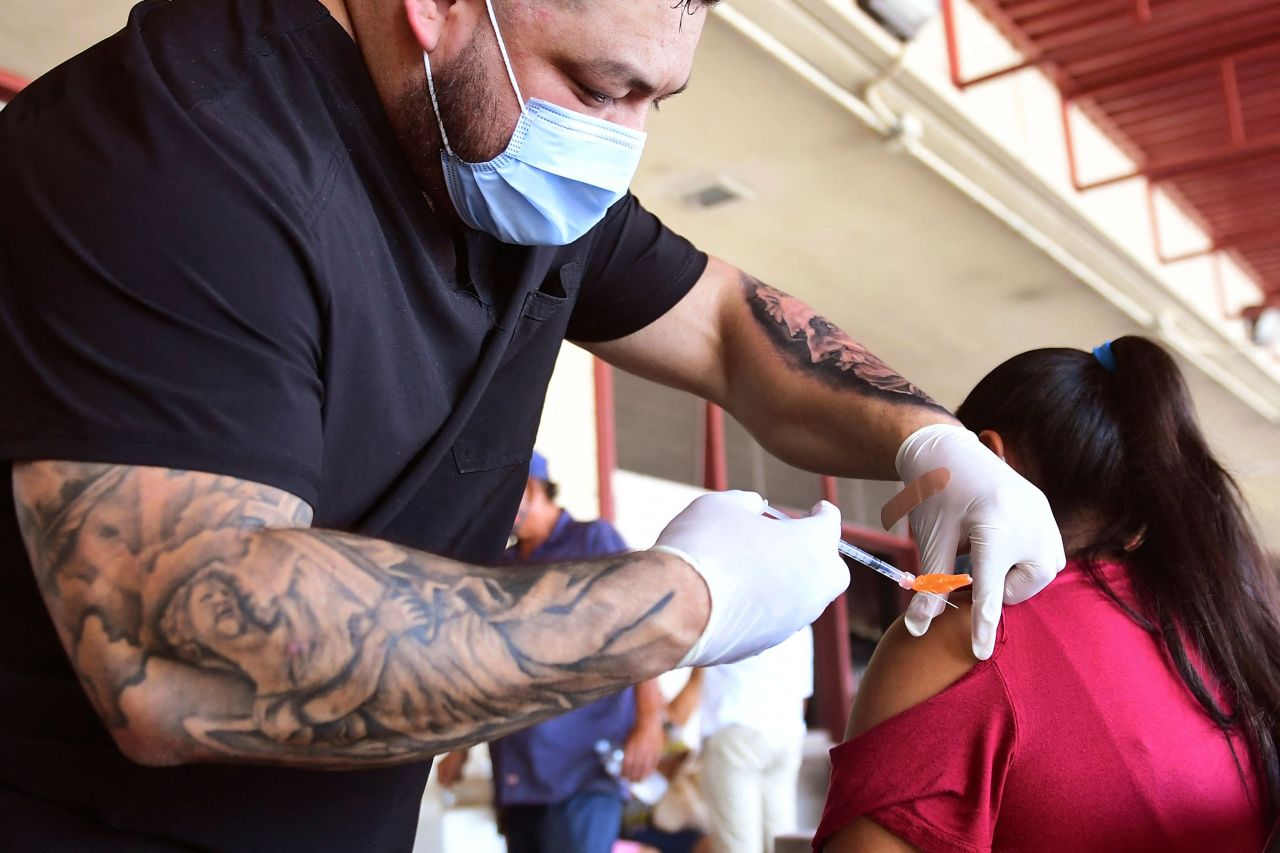 Respiratory Therapist Robert Blas, left, administers a dose of the Pfizer Covid-19 vaccine at a mobile clinic on July 9 in Los Angeles.