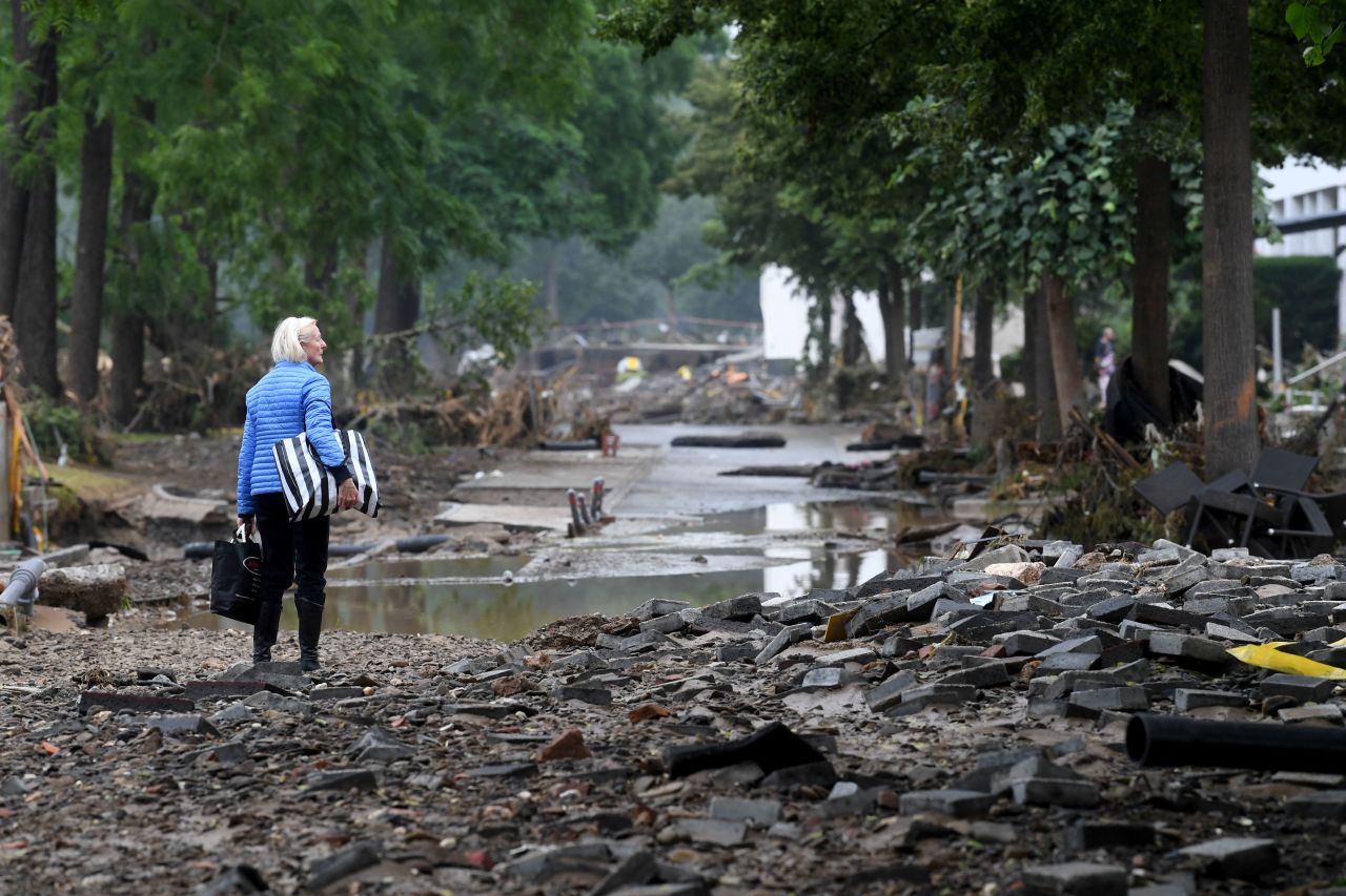 A woman carries bags in a devastated street after the floods caused major damage in Bad Neuenahr-Ahrweiler, western Germany, on July 16.