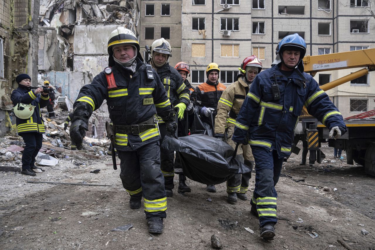 Rescue workers carry the body of a person killed in a Russian missile strike on an apartment building in the southeastern city of Dnipro, Ukraine, on January 16.