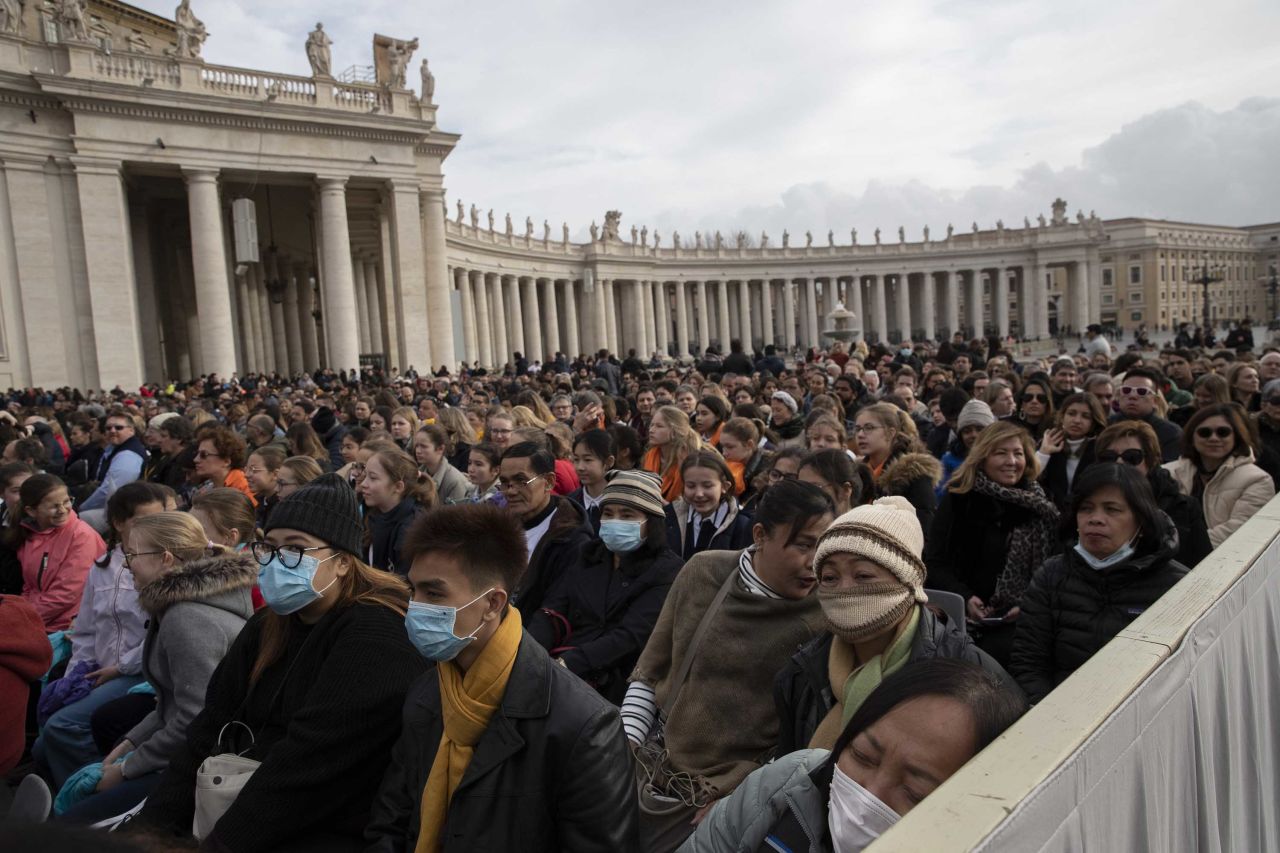 People wear face masks as they wait for Pope Francis' arrival in St. Peter's Square on Wednesday.