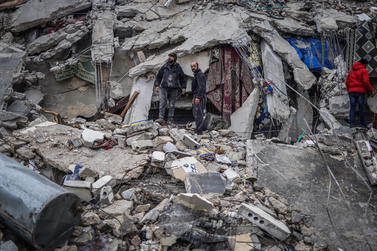 Syrian civilians work to save people trapped beneath a destroyed building in Idlib, Syria, on Monday.