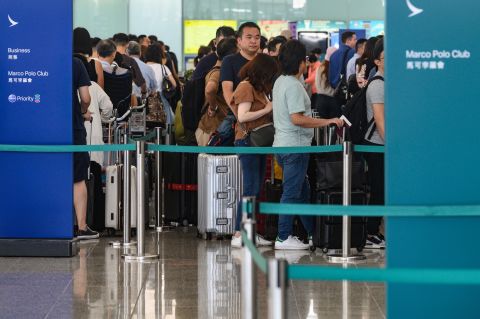 Passengers line up at airline counters at Hong Kong international airport on August 5, 2019.