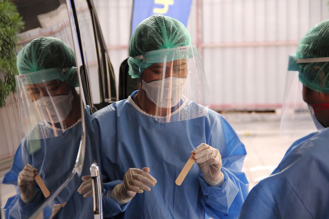 Nurses test people for coronavirus at a drive through service at Ramkhamhaeng Hospital on March 19 in Bangkok, Thailand.