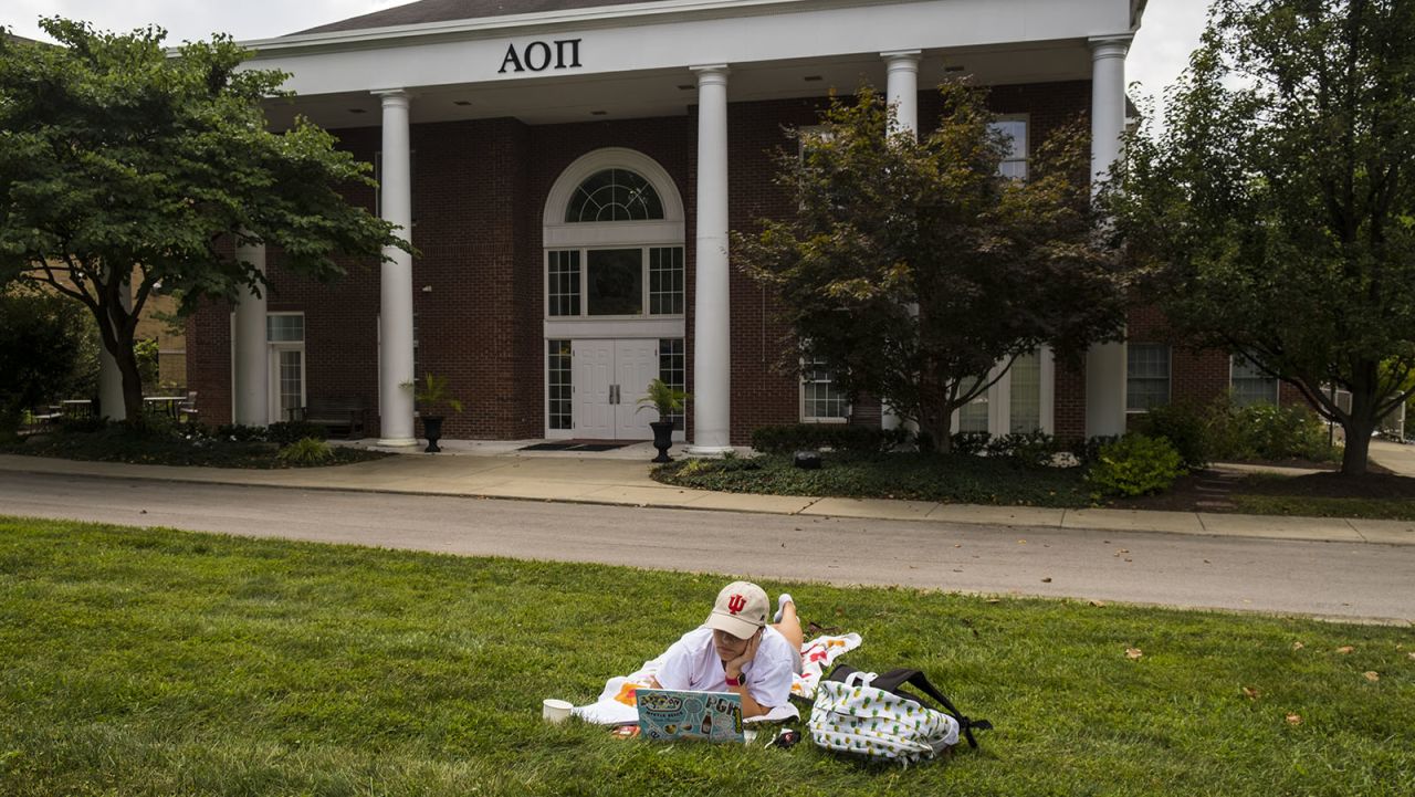 Lexie Brown, a business major at Indiana University, attends an online class on the lawn of her Alpha Omicron Pi sorority house to distance from other house residents. Over 30 Greek houses at Indiana University are currently under quarantine. 