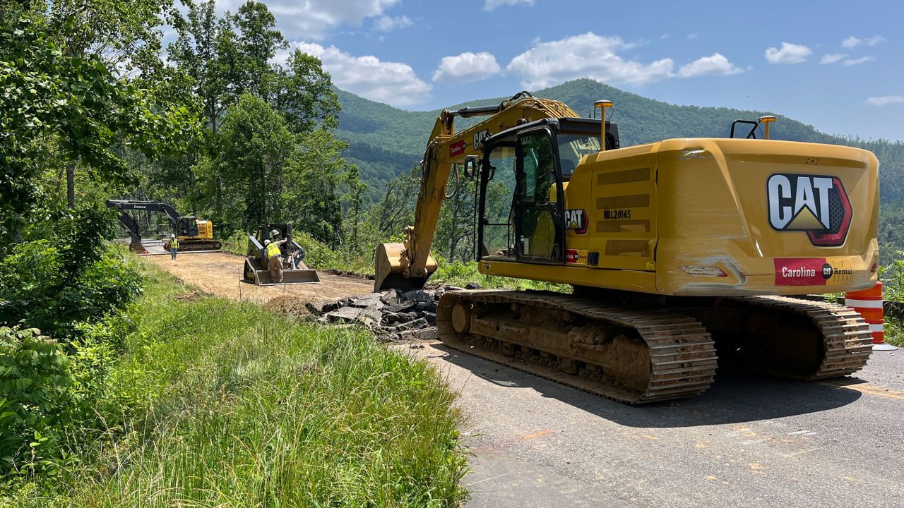 An excavator begins to remove asphalt from the motor road at milepost 375 as work begins to repair a slide caused by hurricane Helene. June 11 2025