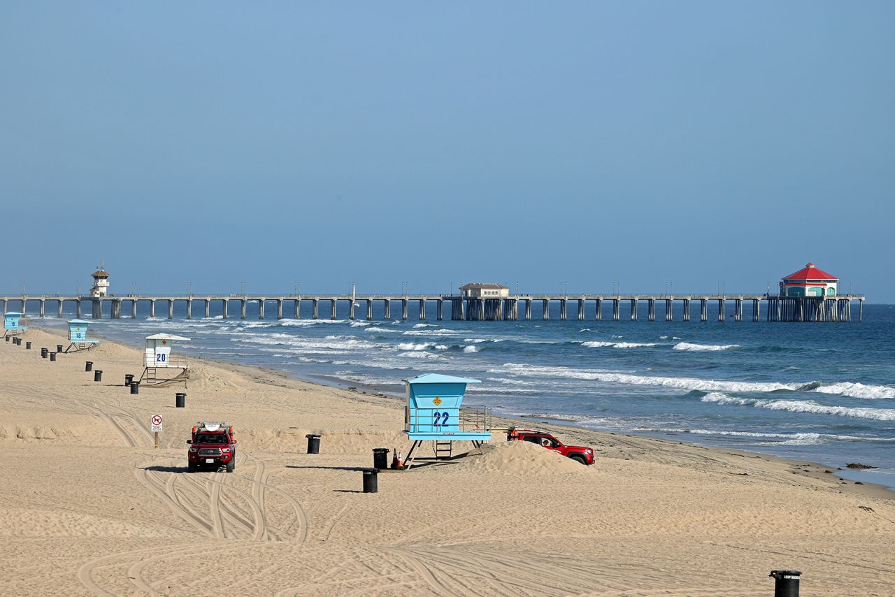 Lifeguards patrol an empty beach in front of the Huntington Beach Pier on Sunday, May 3, in Huntington Beach, California.