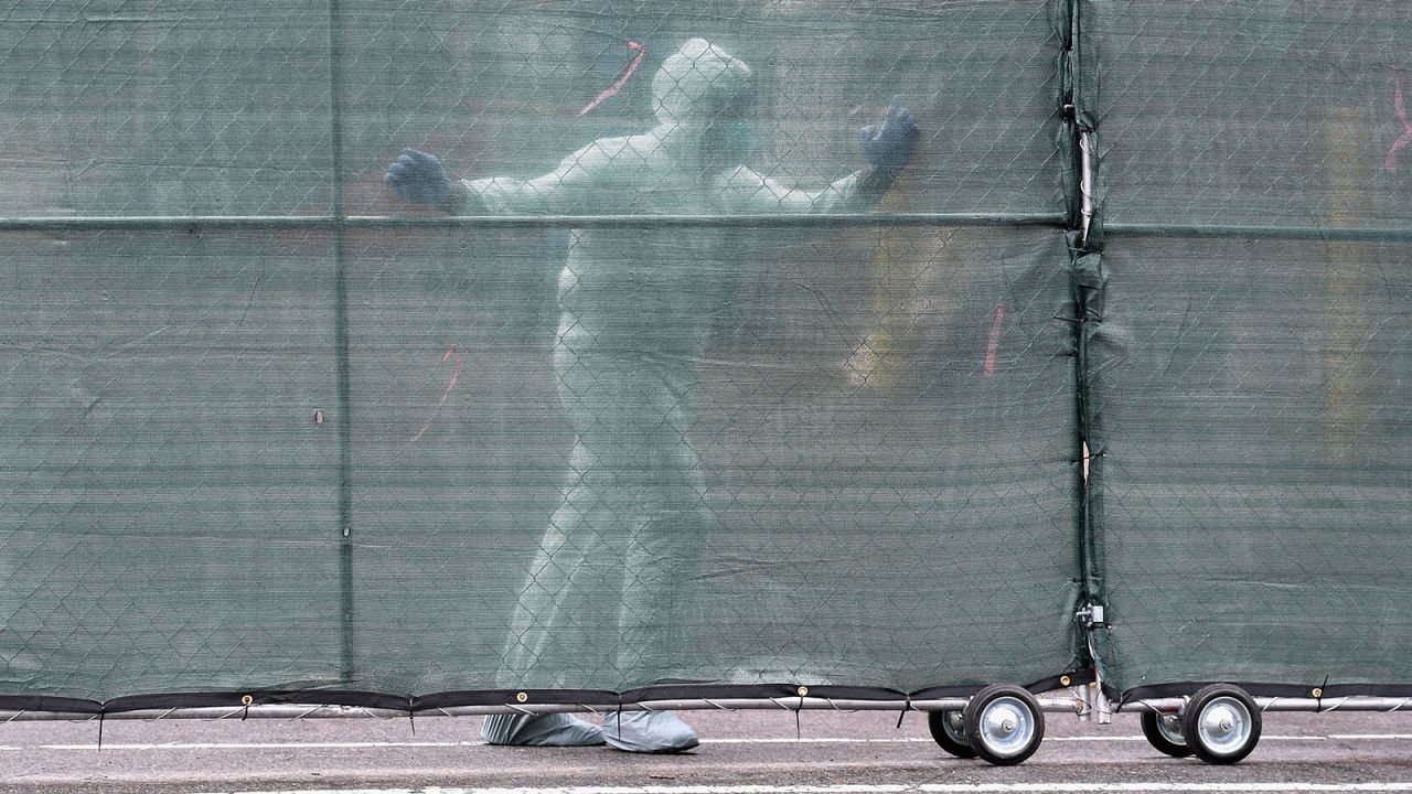 Medical personnel moves a fence in front of refrigerated trucks serving as make shift morgues at Brooklyn Hospital Center in New York City on April 9.