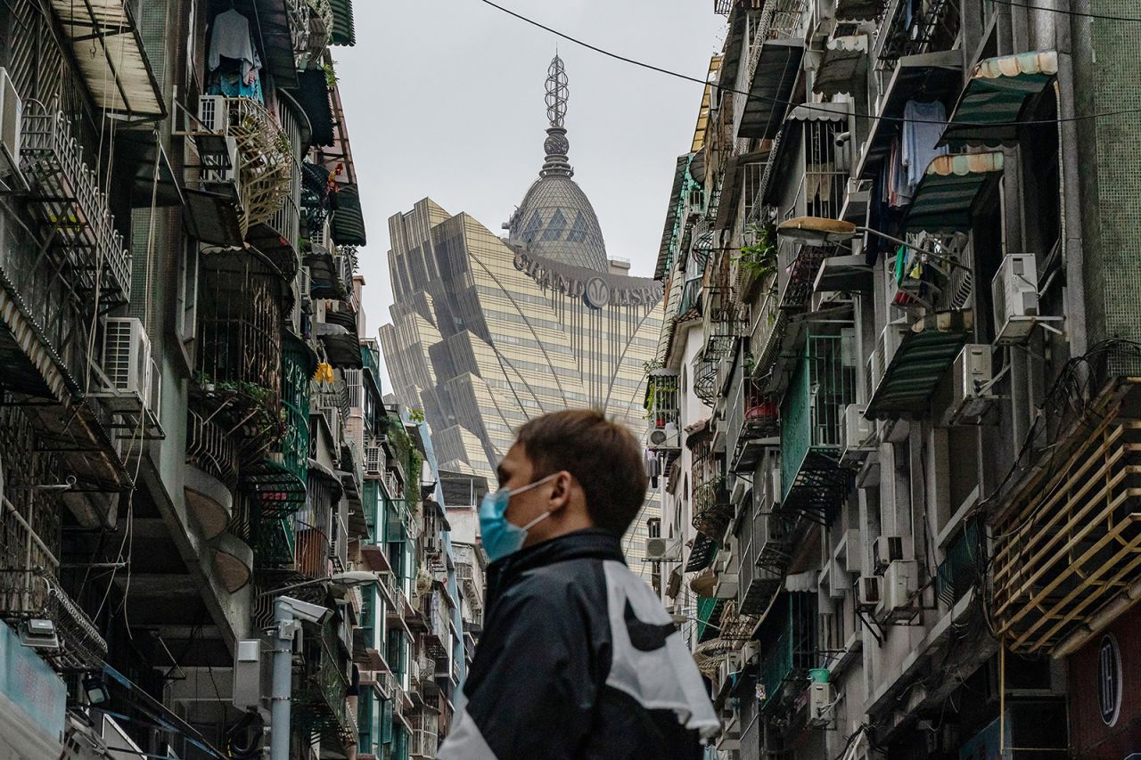 A man wearing a protective mask walks across a street in front of the Grand Lisboa Hotel in a residential district on February 5 in Macau. 