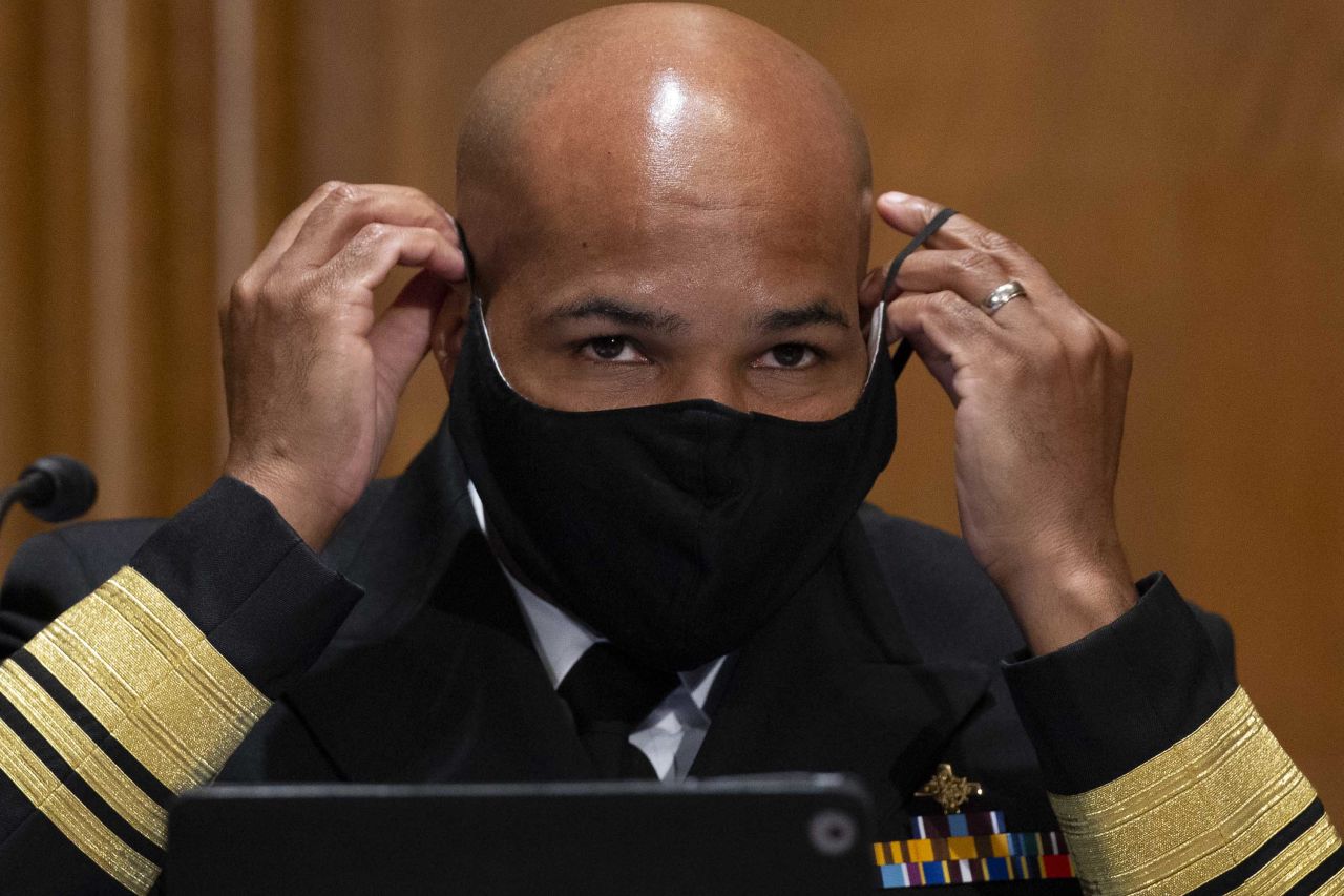 US Surgeon General Dr. Jerome Adams puts on a face mask during a Senate Health, Education, Labor, and Pensions Committee hearing on September 9, in Washington DC.