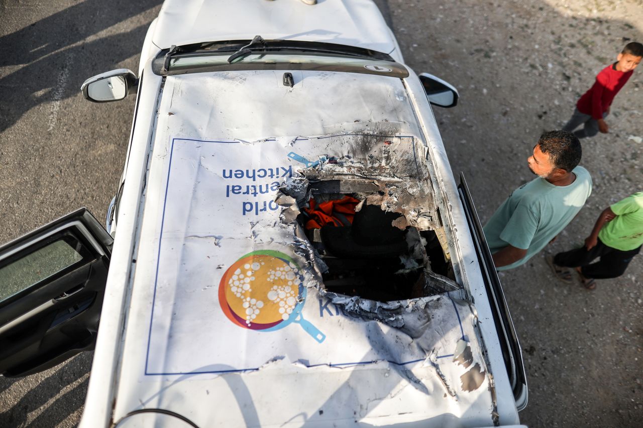 People inspect the damaged vehicle carrying World Central Kitchen staff members after Israeli strike on April 2 in Gaza.
