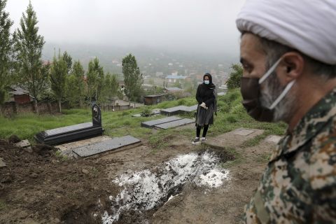 A woman prays at the grave of her mother, who died from Covid-19, at a cemetery in Babol, Iran in this April 30 file photo. 