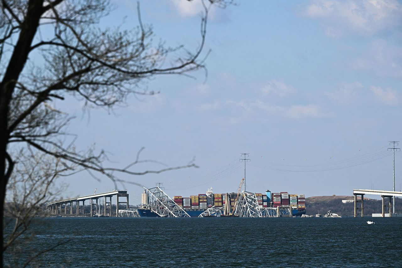 A crane begins clean-up at the collapsed Francis Scott Key Bridge in Baltimore on Friday.