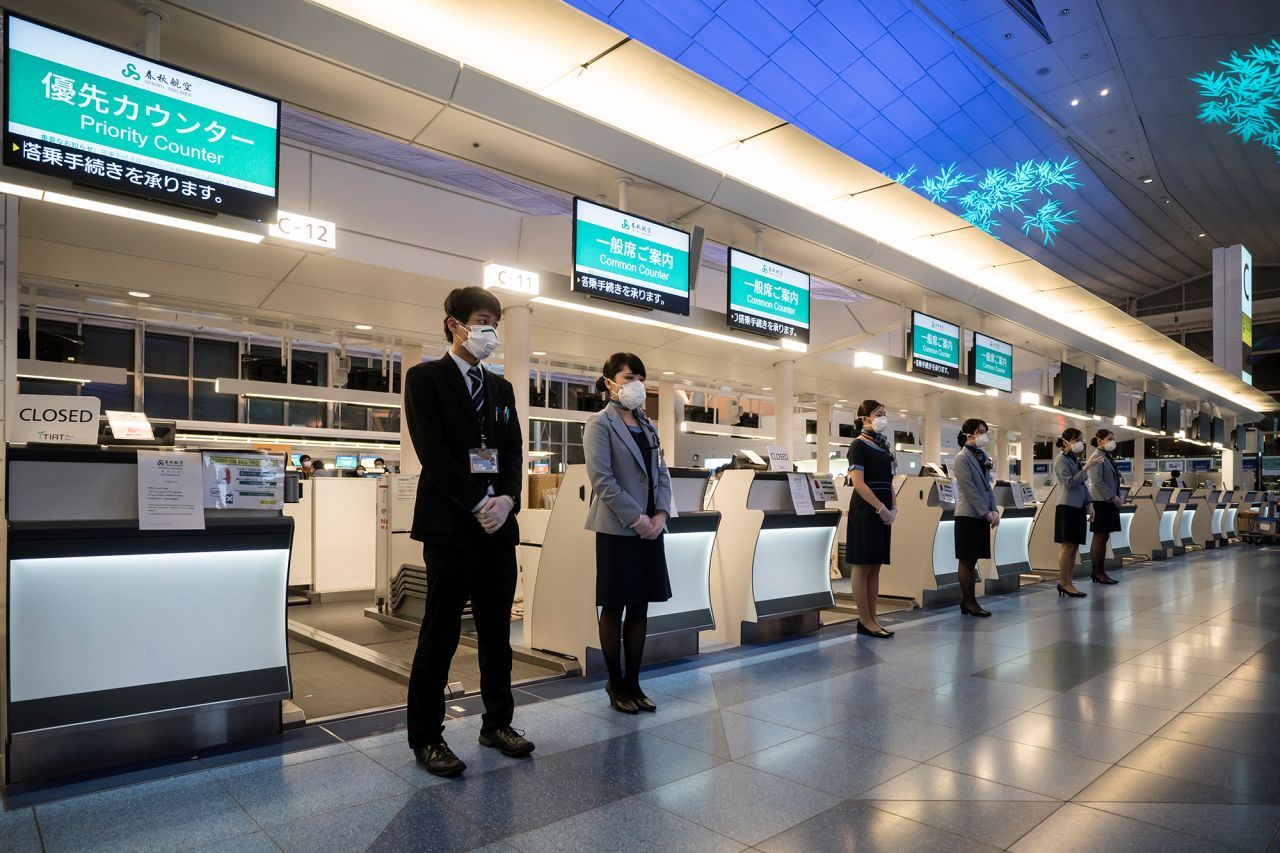 Members of Spring Airlines ground staff stand in front of the check-in counter at Haneda airport on January 31 in Tokyo, Japan.