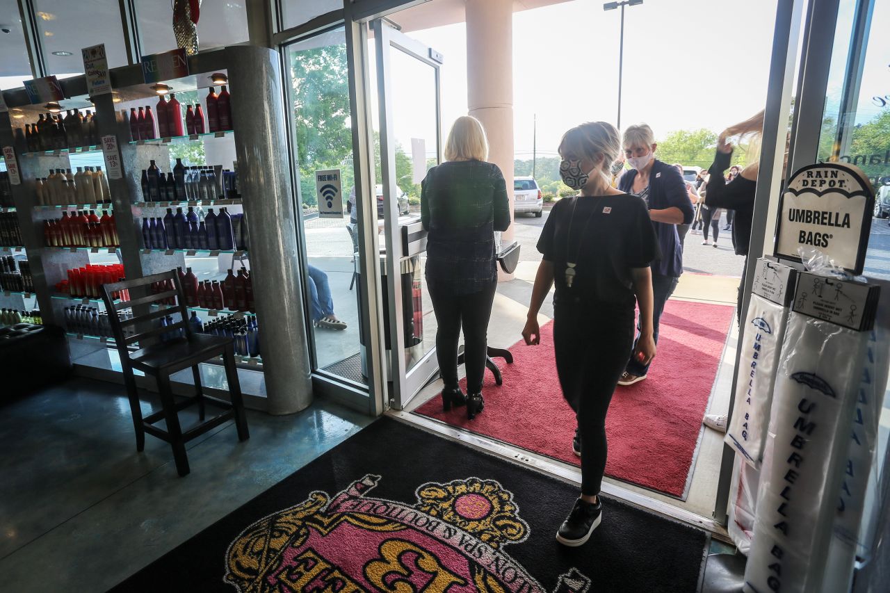 Employees and customers walk into Three-13 Salon, Spa & Boutique in Marietta, Georgia, on April 24. The salon reopened on April 24 after having been closed for more than a month due to the novel coronavirus outbreak.