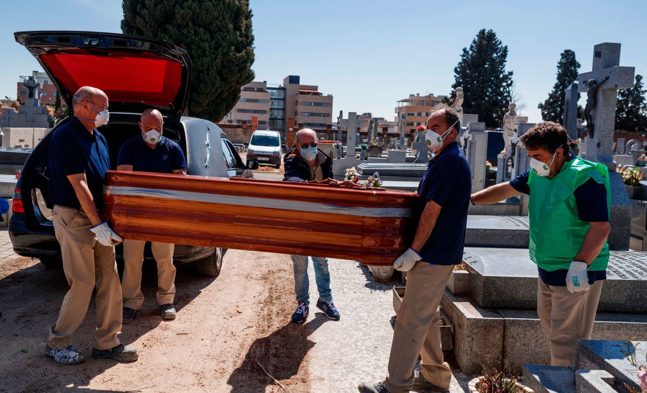 Mortuary employees carry the coffin of a coronavirus victim at the Fuencarral cemetery in Madrid, Spain on March 29.