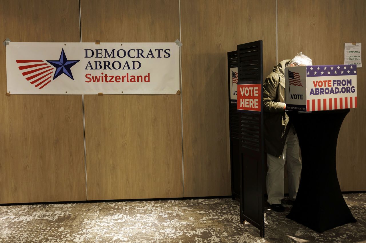 A US citizen living in Switzerland fills in a ballot at a polling station in the Hotel Warwick in Geneva, Switzerland, on Tuesday.