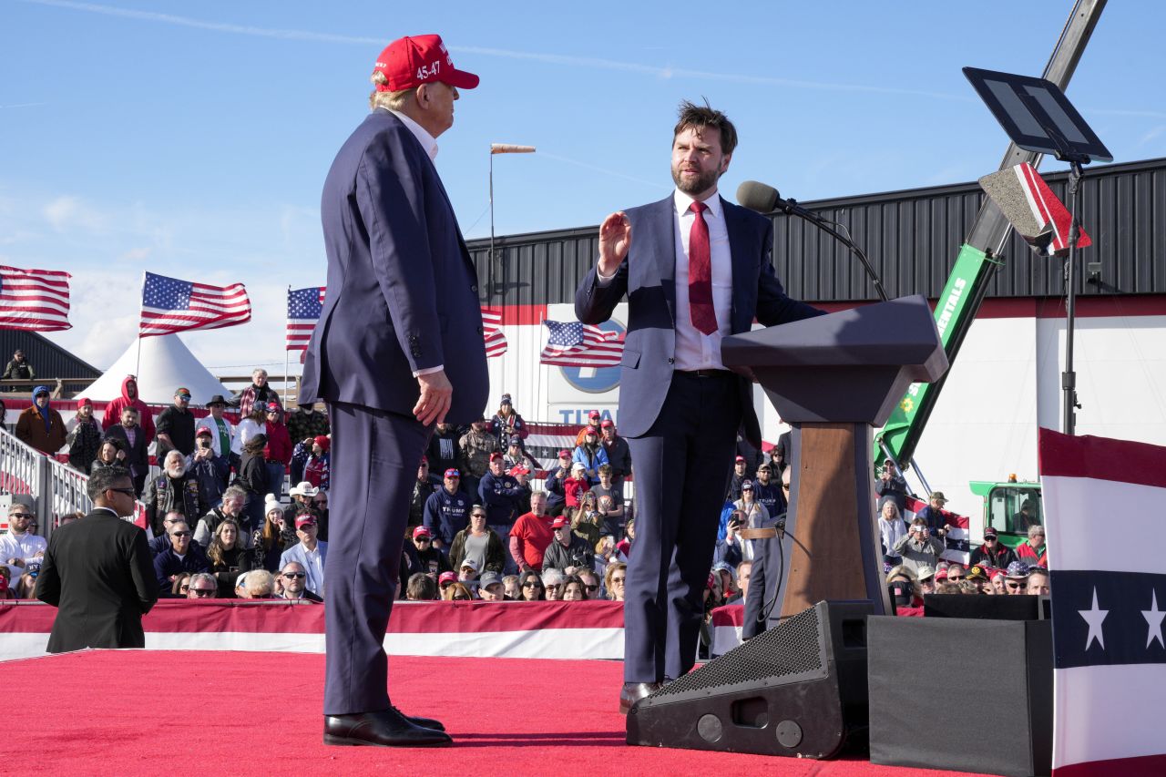 Former President Donald Trump listens as Sen. J.D. Vance speaks at a campaign rally in Vandalia, Ohio, on March 16.