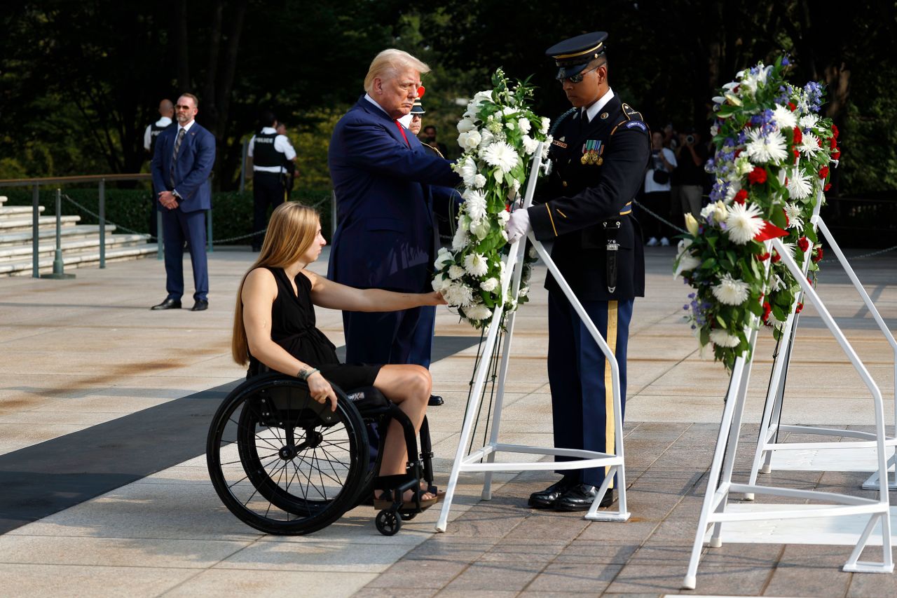 Former President Donald Trump lays a wreath alongside Marine Cpl. Kelsee Lainhart (Ret.), who was injured at the Abbey Gate Bombing, during a wreath-laying ceremony at the Tomb of the Unknown Soldier at Arlington National Cemetery on August 26 in Arlington, Virginia.