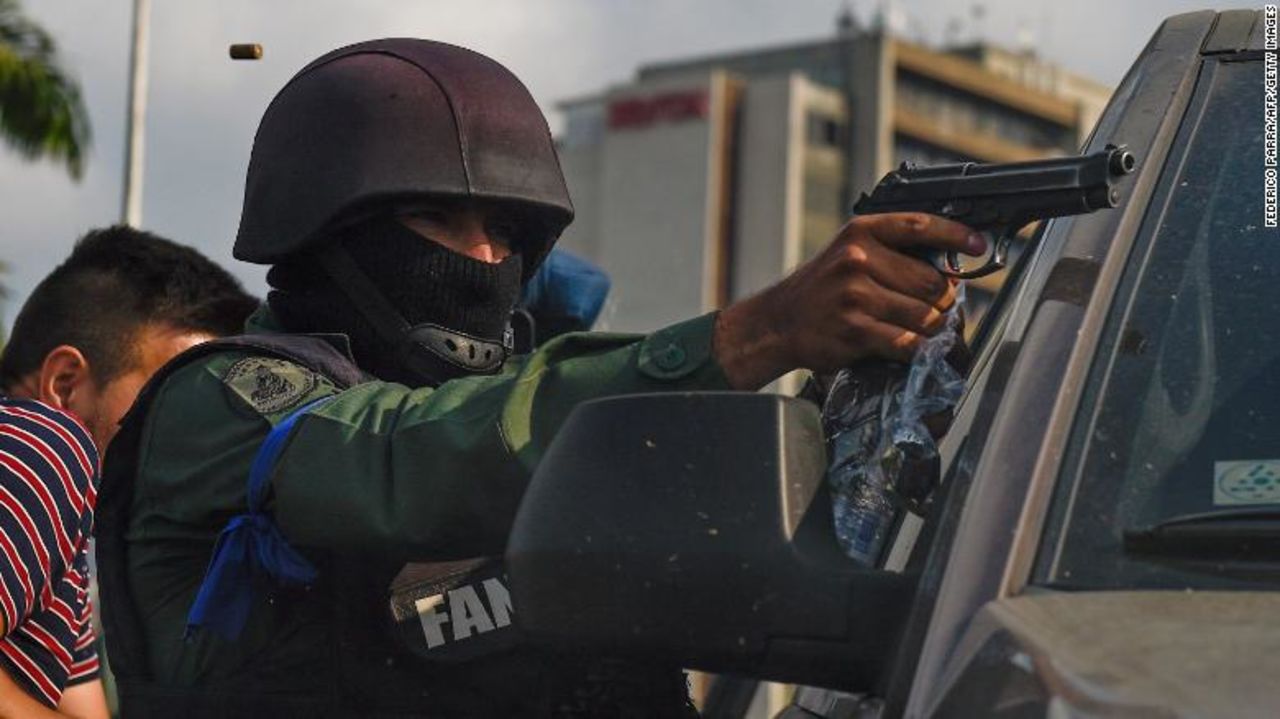 A member of the Bolivarian National Guard who joined Venezuelan opposition leader and self-proclaimed acting president Juan Guaido aims his gun as they repel forces loyal to President Nicolas Maduro.