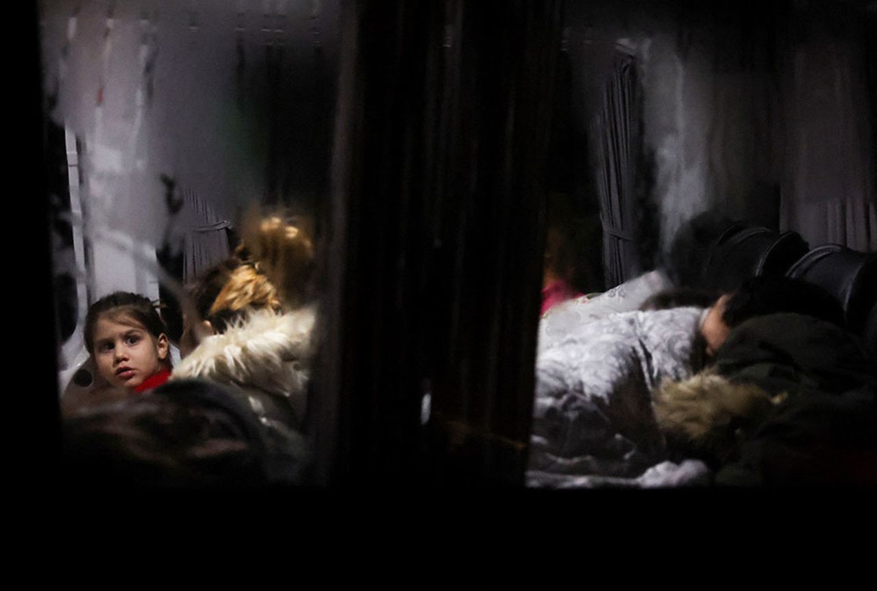 A child watches as people sleep inside a bus in Antakya, Turkey.