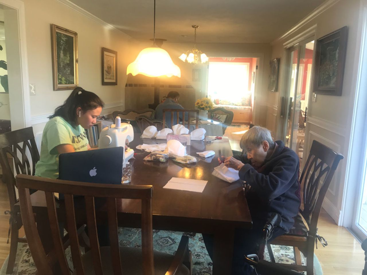 Three generations of a Chinese American family in the Boston area make face masks at home.