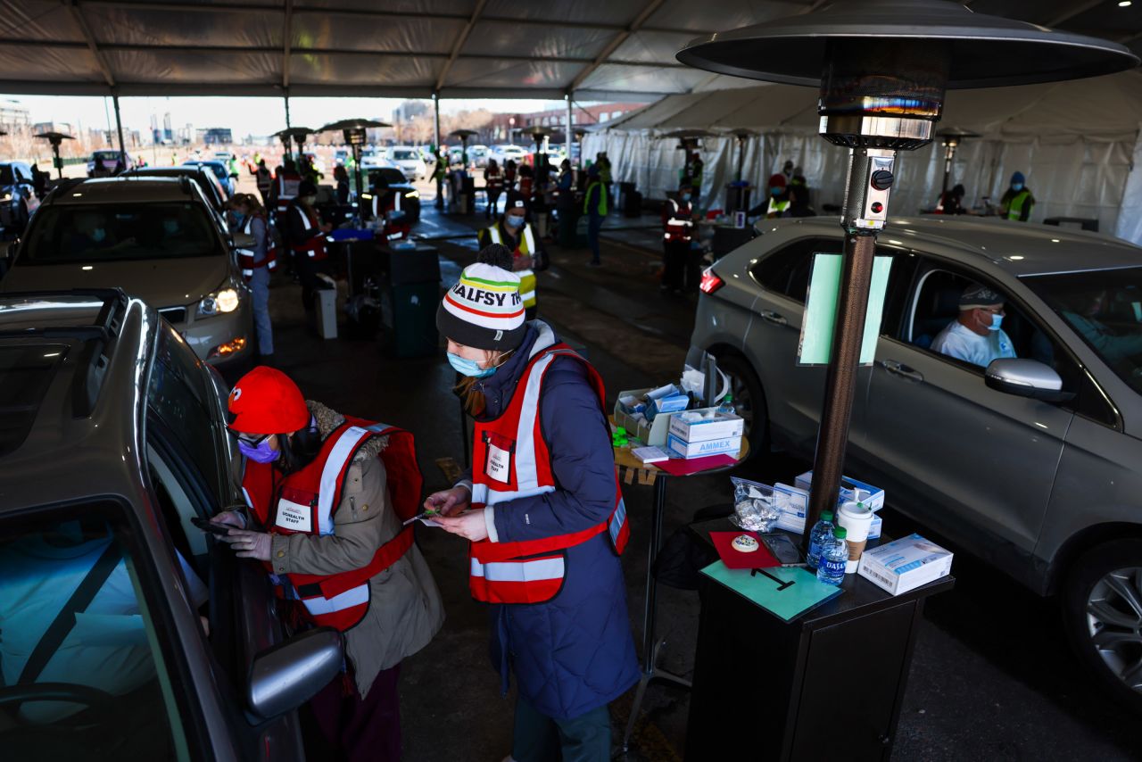 People drive through a tent outside Coors Field as they receive a dose of the Pfizer-BioNTech COVID-19 vaccine during a mass vaccination event on February 20 in Denver, Colorado. 