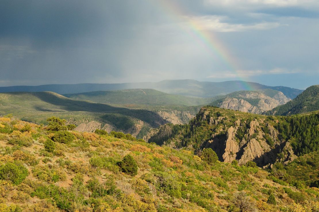 A rainbow stretches over the south rim of Black Canyon.