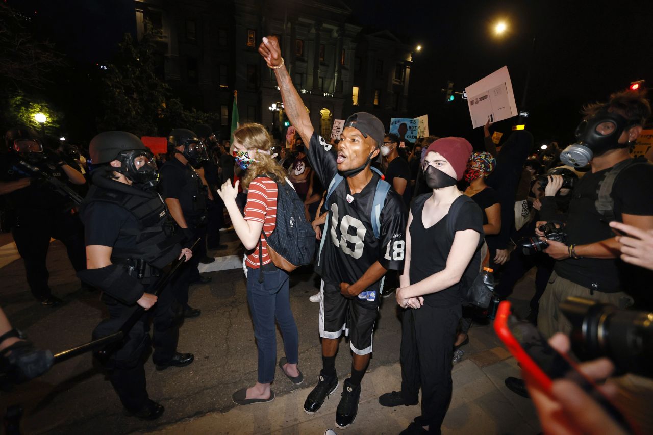 Police stand in front of protesters outside the State Capitol in Denver on May 28.