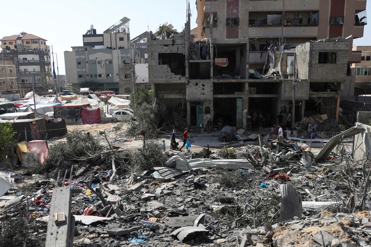 People walk among debris after Israeli strikes in Nuseirat refugee camp, Gaza, on June 9. 