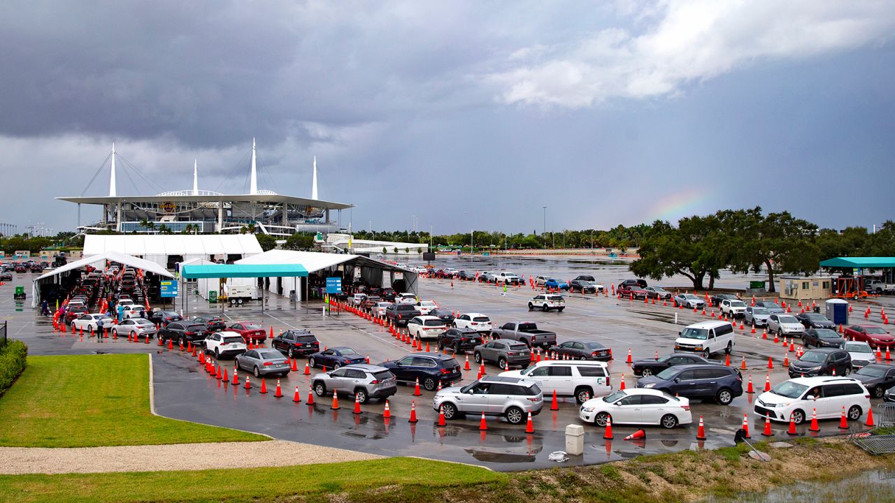 Vehicles line up as a health care workers help to check in people being tested at the Covid-19 drive-thru testing center at Hard Rock Stadium in Miami Gardens, Florida, on November 22.