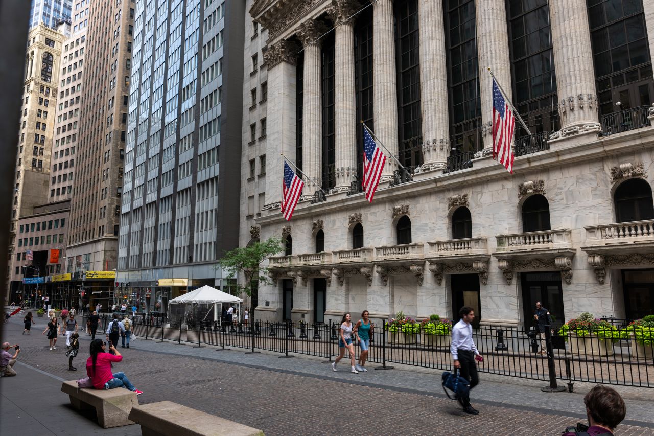 People walk by the New York Stock Exchange on July 11.