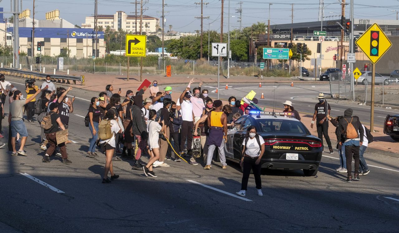 Demonstrators attack a California Highway Patrol cruiser in the Hollywood Freeway in Los Angeles on Wednesday, May 27. 