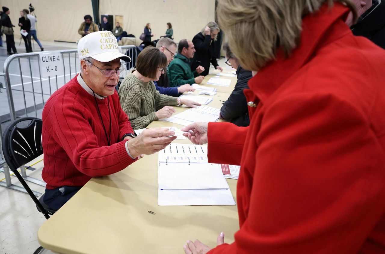 A caucus worker checks in voters at a caucus site at the Horizon Events Center on January 15, in Clive, Iowa.