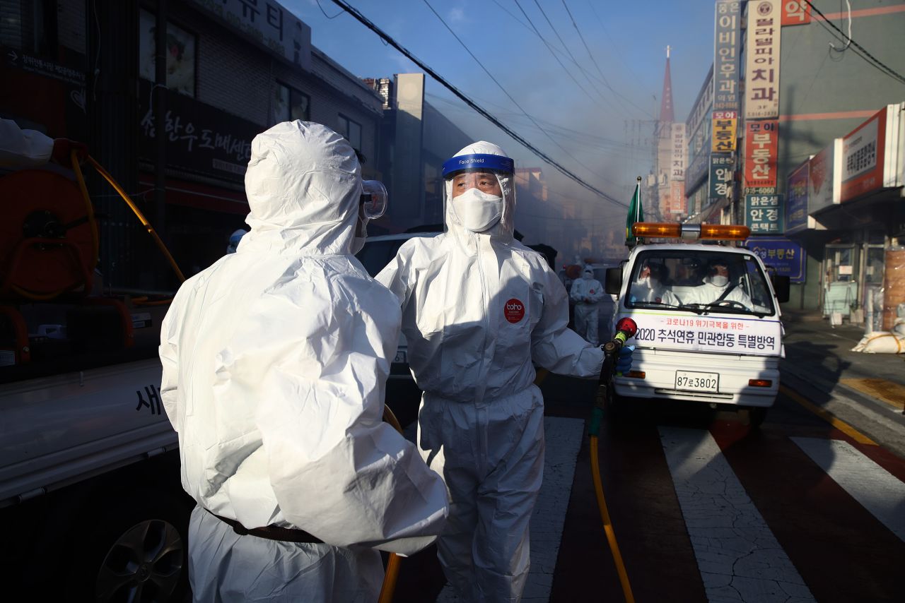 Workers wearing personal protective equipment disinfect a street to prevent?the spread of coronavirus on October 6, in Seoul, South Korea.?