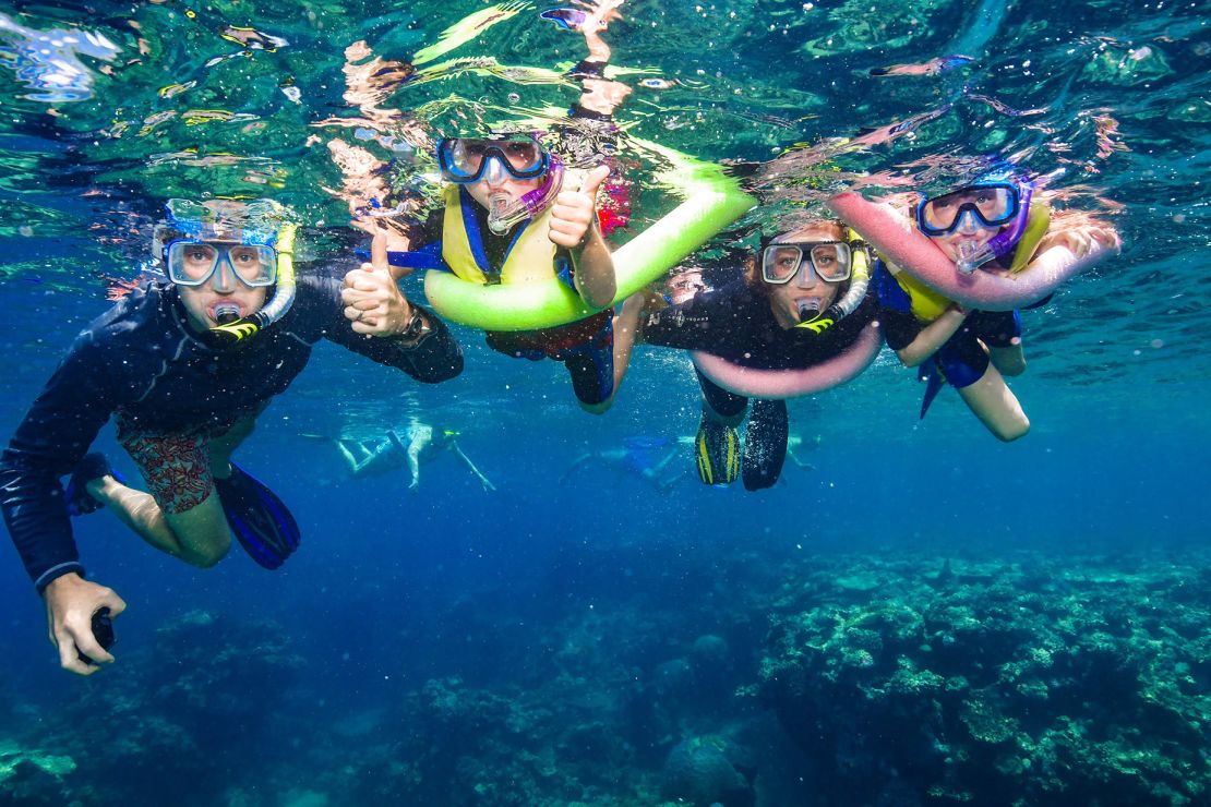 The family snorkeling together in the Great Barrier Reef, Australia.
