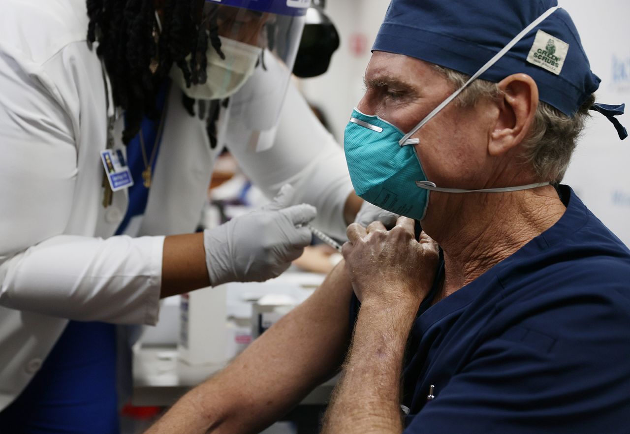 David Woosley, MD at the Jackson Health Systems, receives a Pfizer-BioNtech Covid-19 vaccine from Carol Biggs, CNO at Jackson Memorial Hospital on December 15, 2020 in Miami, Florida. 