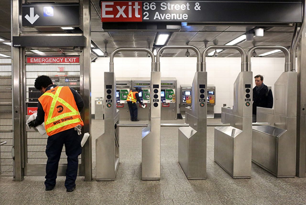 MTA cleaning staff disinfect the 86th St. Q train station on March 4, in New York City.