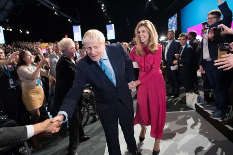 Prime Minister Boris Johnson leaves the conference hall with his girlfriend Carrie Symonds.